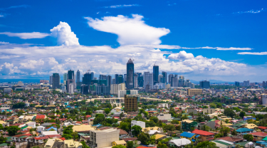 Manila city by Day showing Ortigas and suburban buildings in the foreground With the Bonafacio Global city centered in the background.