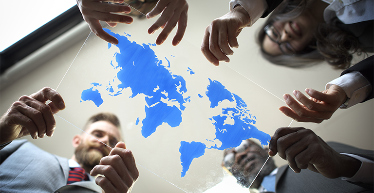 Business people hold map of the world