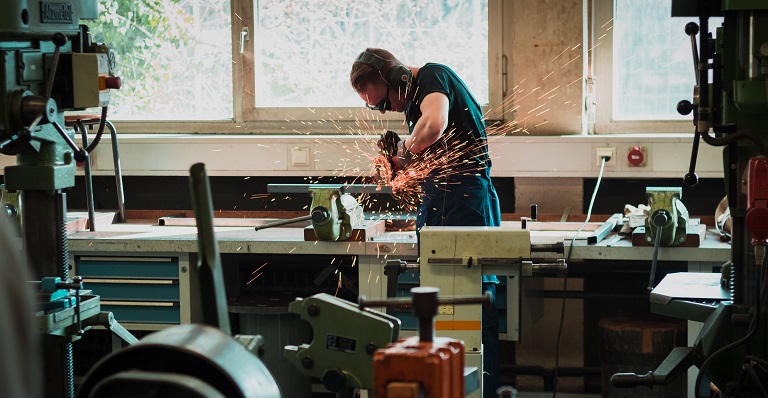 Male metalworker uses welding machine.