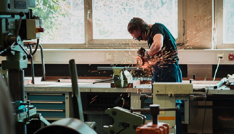 Male metalworker uses welding machine.