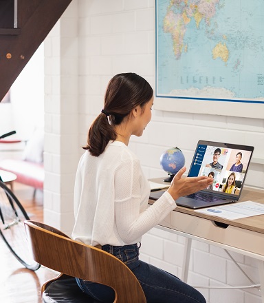 Woman seated at a table participating in a video conference