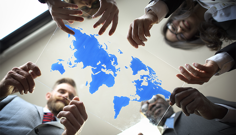 Business people hold map of the world