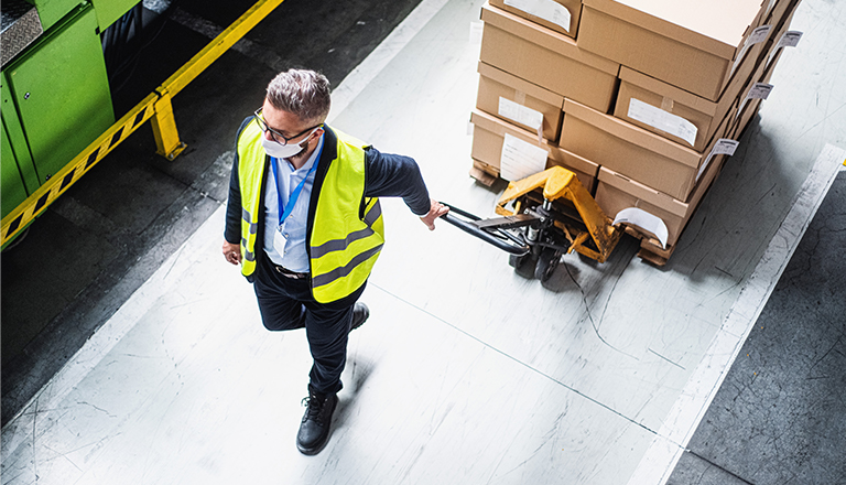 Man pulling boxes on pallet jack