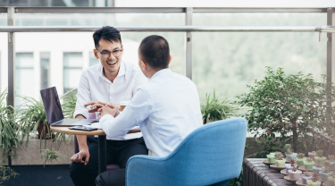 Two businessmen meeting to discuss key performance metrics about their company.