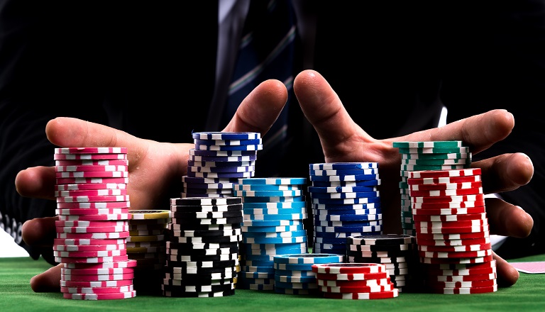 Poker chips stacked high on poker table represent precarious state of global economic, political situation