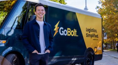 Mark Ang, co-founder of GoBolt, smiling in front of a truck with the GoBolt logo and slogan. 
