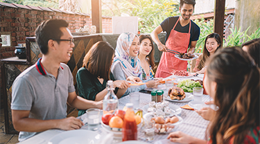 Dans un restaurant en plein air, des amis aux cultures diversifiées discutent ensemble pendant qu’on leur sert une cuisine halale. La demande de produits halals est en hausse en Indo-Pacifique et Exportation et développement Canada possède l’expertise nécessaire pour aider les entreprises canadiennes à percer le marché mondial des produits halals.