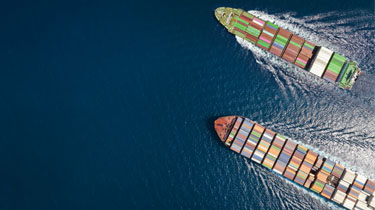 High aerial top down view of two container cargo ships traveling over open ocean